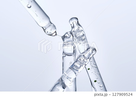 Four different face serum pipettes on a neutral background. 127909524