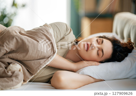 Woman is sleeping in her bedroom 127909626