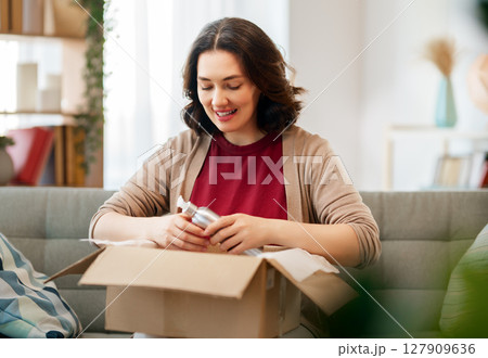 Woman is unpacking cardboard 127909636