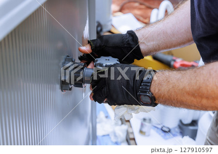 Skilled technician is adjusting mechanical valve filter system to swimming pool 127910597