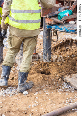 Close-up of soil sampling during pile drilling process. Extraction of subsurface material for geotechnical analysis and foundation assessment 127910605