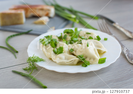 Appetizing dumplings with potatoes and onions on a rustic table 127910737