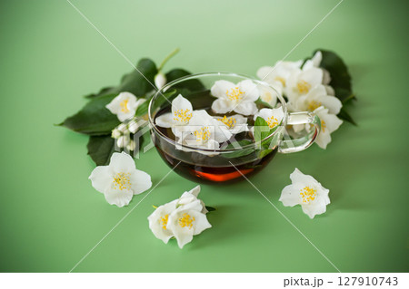 Natural green tea with jasmine petals on the table Natural green tea with jasmine petals on the table 127910743
