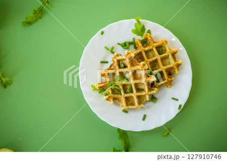 Vegetable zucchini waffles with greens on a green background Vegetable zucchini waffles with greens on a green background 127910746