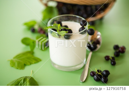 Healthy fermented milk product with berries and spoon 127910758