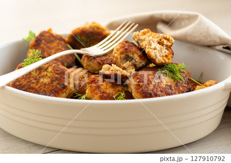 Delicious fried cutlets in a baking dish on a white table 127910792