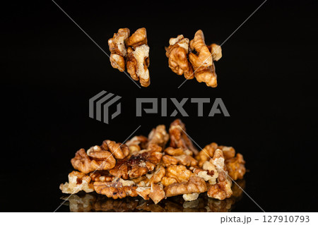 a handful of peeled walnuts on a black background a handful of peeled walnuts on a black background 127910793