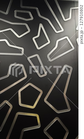 Abstract black background with metallic geometric cutout shapes creating a modern and futuristic design. Represents innovation, technology, and contemporary style concept 127910802