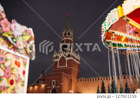 Spasskaya Tower of Moscow Kremlin shining at night next to carousel during christmas holidays Spasskaya Tower of Moscow Kremlin shining at night next to carousel during christmas holidays 127911150