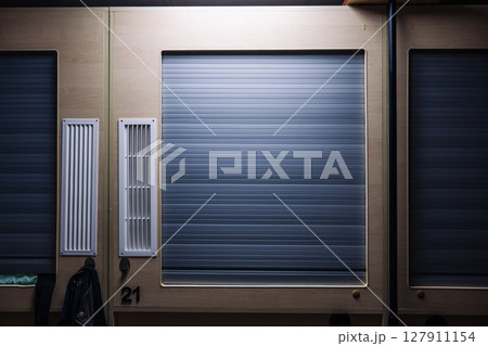 Capsule hotel room door closing, providing privacy and rest for travelers Capsule hotel room door closing, providing privacy and rest for travelers 127911154