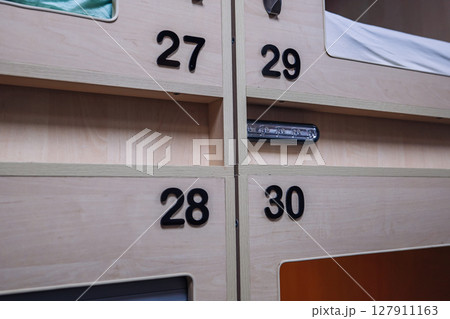 Numbered capsule hotel rooms offering privacy and comfort Numbered capsule hotel rooms offering privacy and comfort 127911163