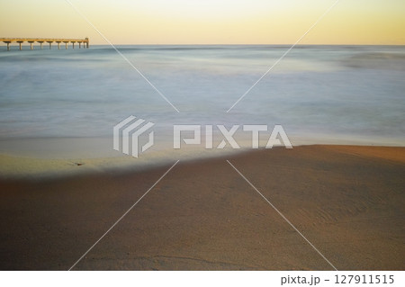 早朝の砂浜に打ち寄せる波 早朝の砂浜に打ち寄せる波 127911515