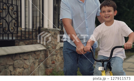 father teaches child ride bike, mother father, adrenaline horse riding, boy laughs smiling sitting bike outdoors, child riding father mother nature, together riding child kid bike, horse riding, walk 127911573