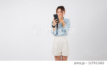 Woman shock asian hold surprise mouth worry emotion reading mobile phone seeing bad news on her mobile phone she covers her mouth looking scared, isolated studio white background Woman shock asian hold surprise mouth worry emotion reading mobile phone seeing bad news on her mobile phone she covers her mouth looking scared, isolated studio white background 127911882