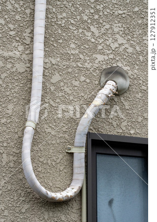 住宅の外壁に設置されたエアコン配管 127912351