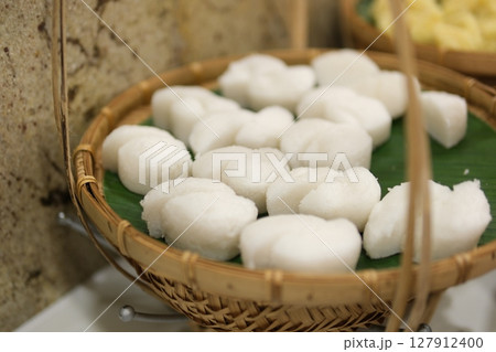 Indonesian traditional food called lemper contains sticky rice 'beras ketan' with shredded chicken inside. It tastes savory and delicious.Wrapped in banana leaves. White background 127912400