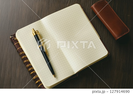 White Notebook and Pen on a Wooden Table, Perfect for Note-Taking and Creative Ideas 127914690