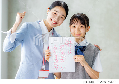 テストで高得点を取った生徒と教師 127914871
