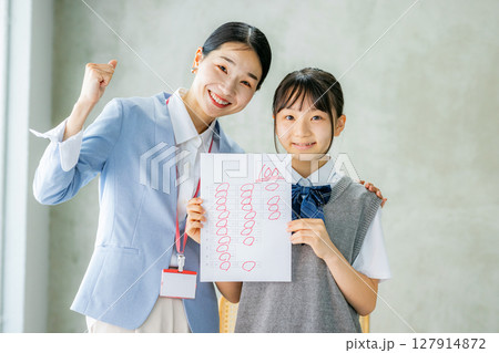 テストで高得点を取った生徒と教師 127914872