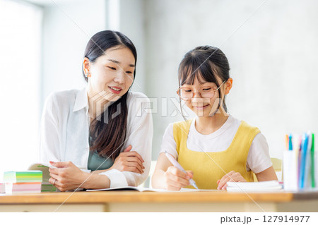 勉強をする小学生と教えるママ 127914977