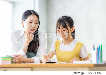 勉強をする小学生と教えるママ 127914978