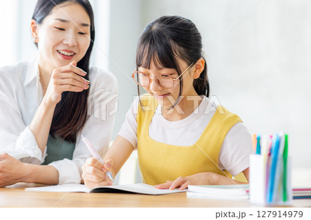 勉強をする小学生と教えるママ 127914979