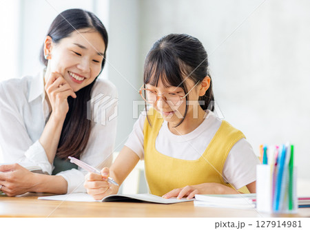 勉強をする小学生と教えるママ 127914981