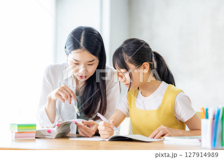 勉強をする小学生と教えるママ 勉強をする小学生と教えるママ 127914989