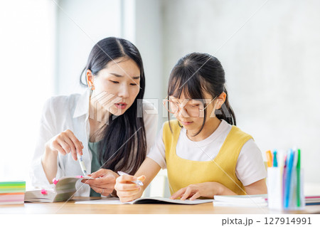 勉強をする小学生と教えるママ 勉強をする小学生と教えるママ 127914991