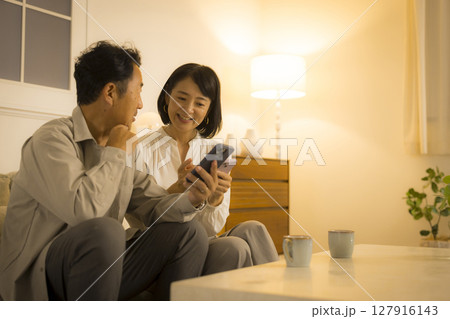 夜のリビングのミドル夫婦　　 127916143