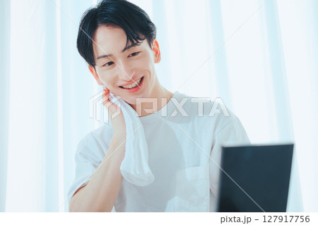 朝の洗顔後、鏡の前でタオルを使う爽やか男子 127917756