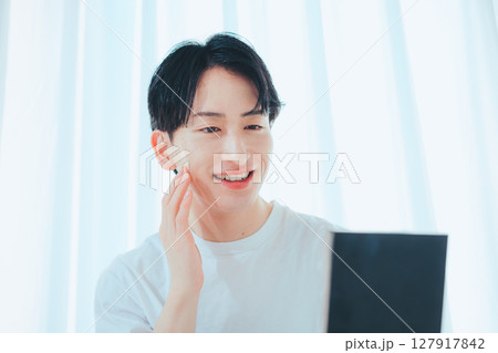 鏡でスキンチェックをする爽やか男子 — メンズスキンケア習慣 127917842