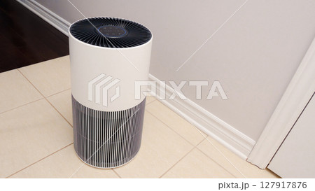 Sleek Modern Tall Air Purifier with Black Fan on Beige Tile Floor in Stylish Room Sleek Modern Tall Air Purifier with Black Fan on Beige Tile Floor in Stylish Room 127917876