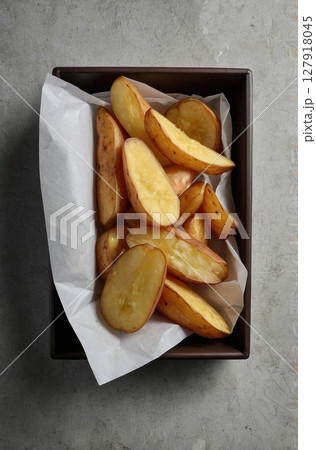 Delicious Potato Wedges in a Brown Tray A Rustic Culinary Delight for Food Photography Delicious Potato Wedges in a Brown Tray A Rustic Culinary Delight for Food Photography 127918045