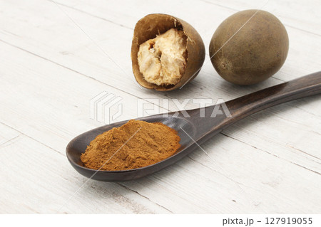 白板に置かれた羅漢果と匙に盛られた羅漢果パウダー 127919055