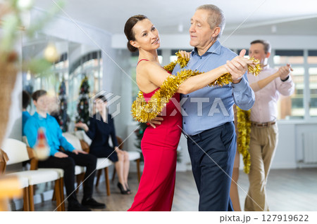 Elderly man dancing slow dance with woman during New Year corporate party Elderly man dancing slow dance with woman during New Year corporate party 127919622