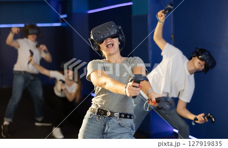girl in virtual reality helmet crouches down and dodges flying asteroids during space adventure game 127919835
