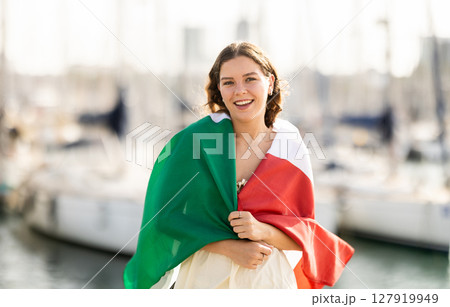 Woman waving Italian flag against seaport and yachts 127919949
