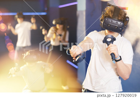 Excited guy having fun with friends in virtual reality room Excited guy having fun with friends in virtual reality room 127920019