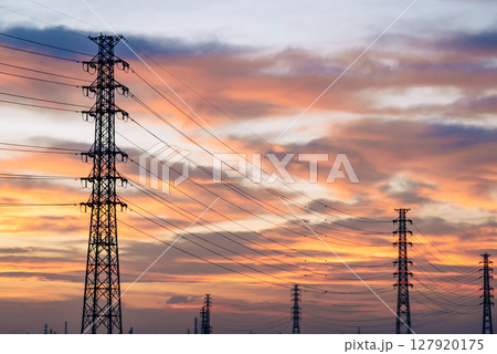 夕焼けに染まる空と立ち並ぶ送電鉄塔　フィルム調 127920175