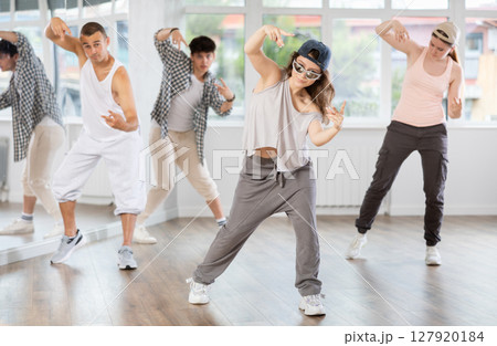 Group of young people perform choreographic exercises and teaches energetic mobile social dance waacking together 127920184