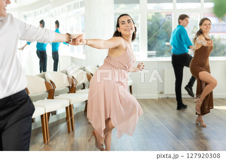 Young woman with partner dancing twist 127920308