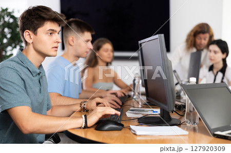 Concentrated junior software developer working in IT startup 127920309