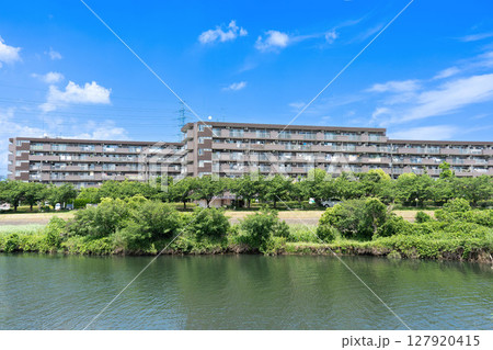 川沿いにある茶色い低層マンション 127920415