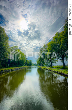 Majestic and Serene River Reflections Surrounded by Lush Greenery and Natures Beauty 127920575