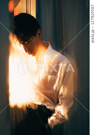 韓国風若手ビジネスマン 夕暮れ光の白シャツポートレート 127920587