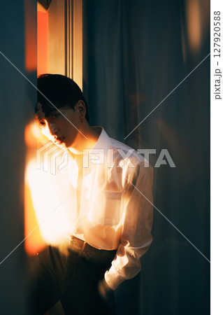 韓国風若手ビジネスマン 夕暮れ光の白シャツポートレート 127920588
