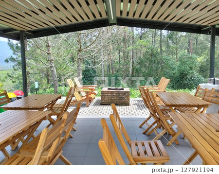 Outdoor dining area with wooden furniture and a view of the forest Outdoor dining area with wooden furniture and a view of the forest 127921194