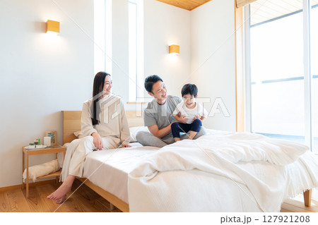 寝室で会話する若い家族 寝室で会話する若い家族 127921208