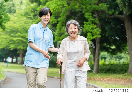散歩するシニア女性と介護士 127921517